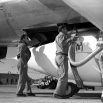 Technicians servicing the Bell Aircraft Corporation X-1 in preparation for a flight. The X-1 is mated with the Boeing B-29. The hooks and strap that holds the X-1 in place under the B-29 can be seen just above the hand of the technician with the hose. The strap continues under the belly of the X-1 and holds the aircraft to the mothership until the word comes to "launch", and then the shackles are released. (NASA photo)