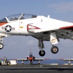 A T-45 Goshawk assigned to Training Airwing One flies by three other chocked-and-chained Goshawks while approaching for an Touch and Go on board r USS Harry S. Truman in 2007 (US Navy photo)