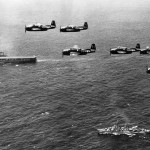 Six U.S. Navy Grumman TBM-3E Avenger anti-submarine aircraft of Composite Squadron VC-22 Checkmates flying over the Mediterranean Sea. This squadron was Attack Squadron VA-2E until 4 August 1948. Below are the aircraft carrier USS Coral Sea (CVB-43) and the Gearing-class destroyer USS Bordelon (DD-881).