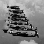 Seven Grumman TBM-3D Avenger bombers of night torpedo squadron VT(N)-90 flying in formation in January 1945. The squadron was part of Night Air Group 90 on the carrier USS Enterprise (CV-6). Note radar pods in right-side wings, and the distinctive tail insignia.